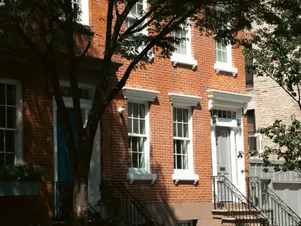 Brick townhouse on a sunny tree-lined street